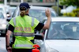 A police officer stops a driver at a checkpoint at Coolangatta on the Queensland - New South Wales border.