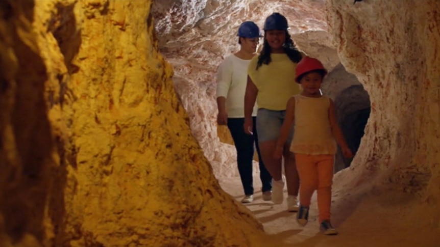 Kids and their mum wearing a helmet walking through a tunnel