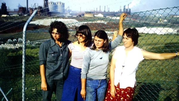 Four women stand outside the wire fence of the Port Kembla BHP steelworks.