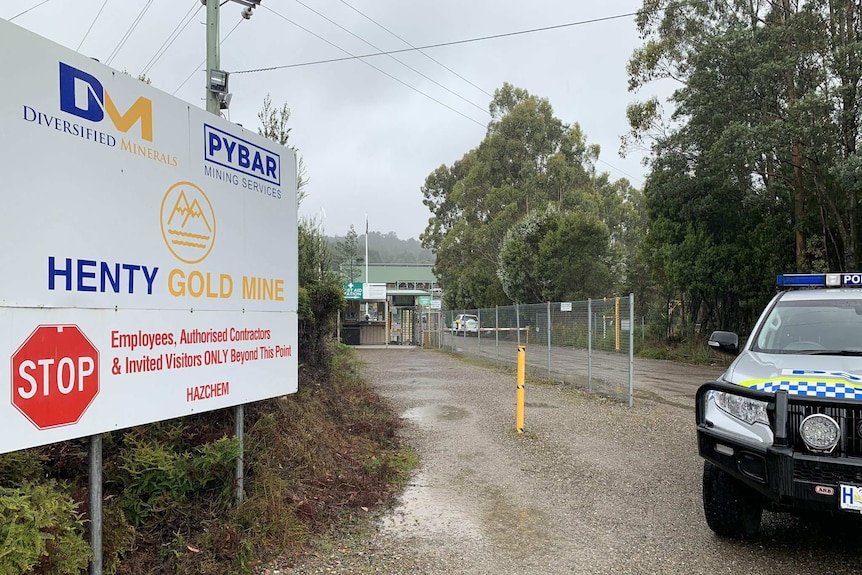 A police car is parked next to a sign for Henty Gold Mine.