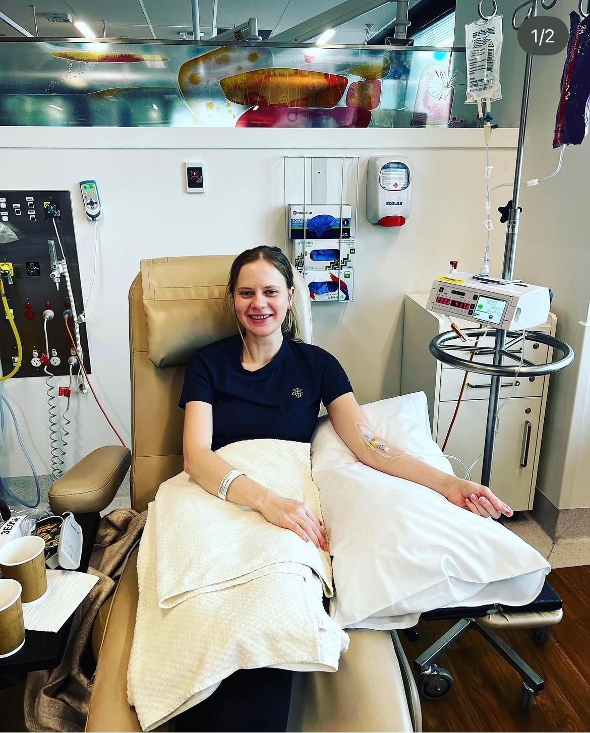A woman sitting in a chair getting chemo. 