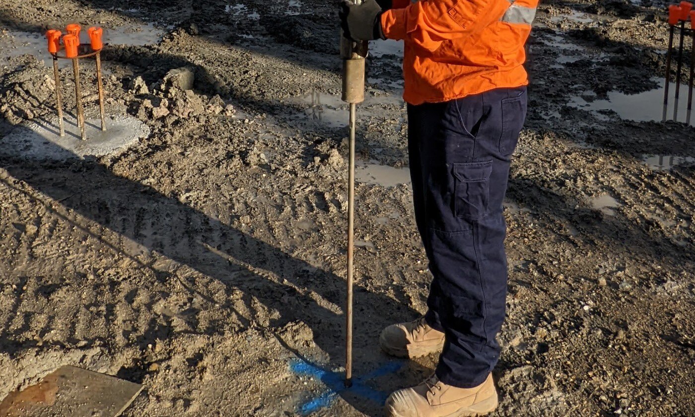 solo sendo analisado por um homem vestido com roupas de construção