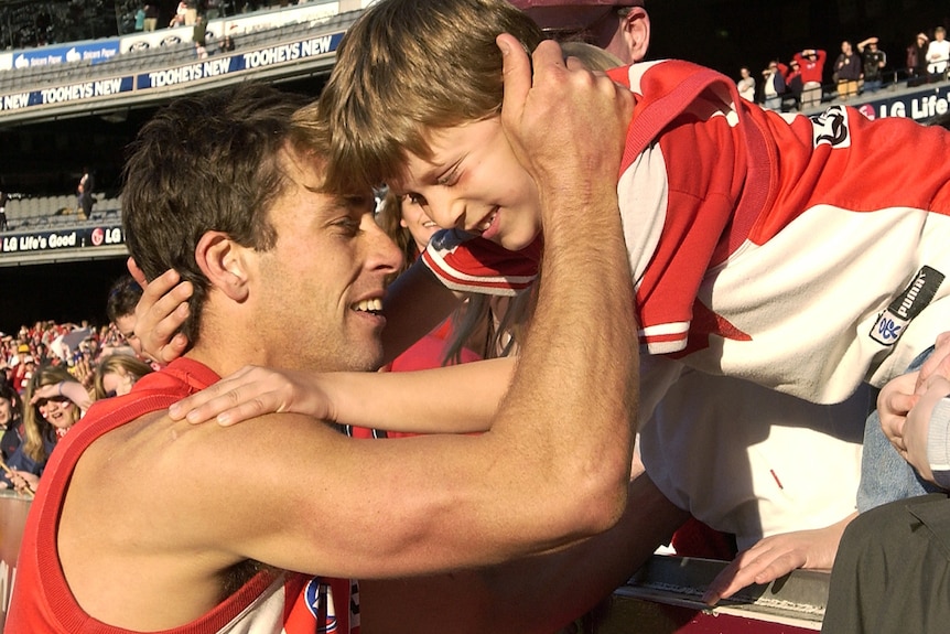 Andrew Dunkley hugs a young Josh Dunkley over the MCG fence