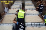 A still from a video shows huge buckets full of pills and members of Italy's police and customs.
