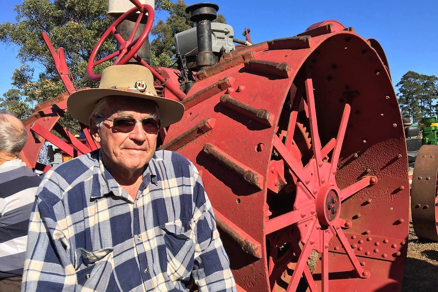 Maryborough cane farmer Jeff Schmidt standing in front of a vintage tractor