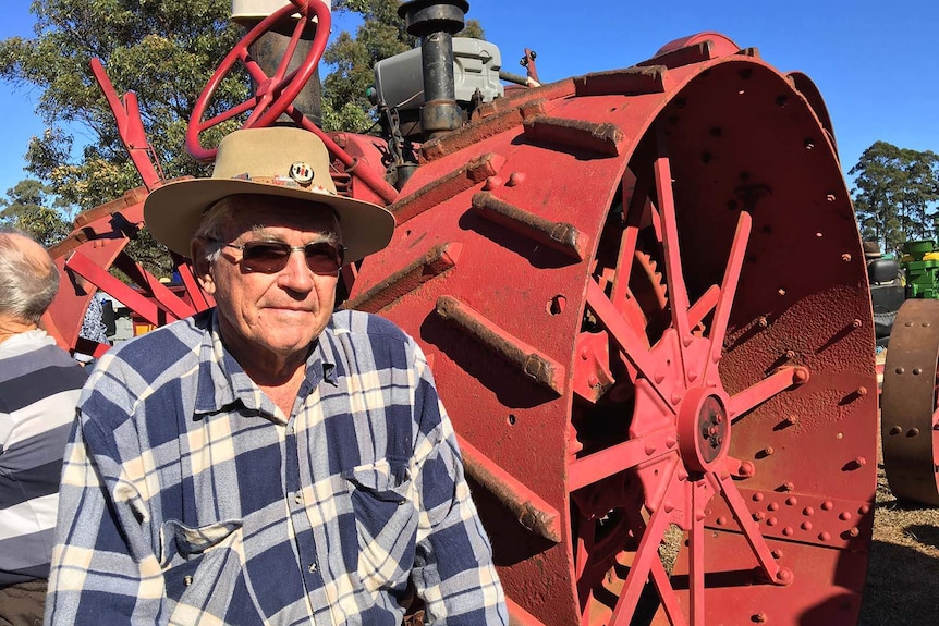 Maryborough cane farmer Jeff Schmidt standing in front of a vintage tractor