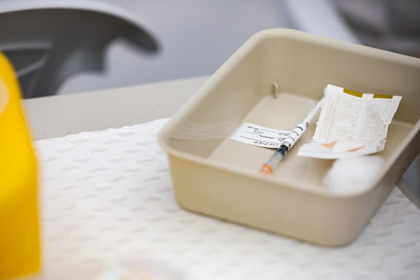 A needle sitting in a tray.