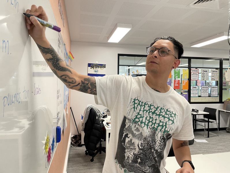 Milton Henriquez writes on a whiteboard.