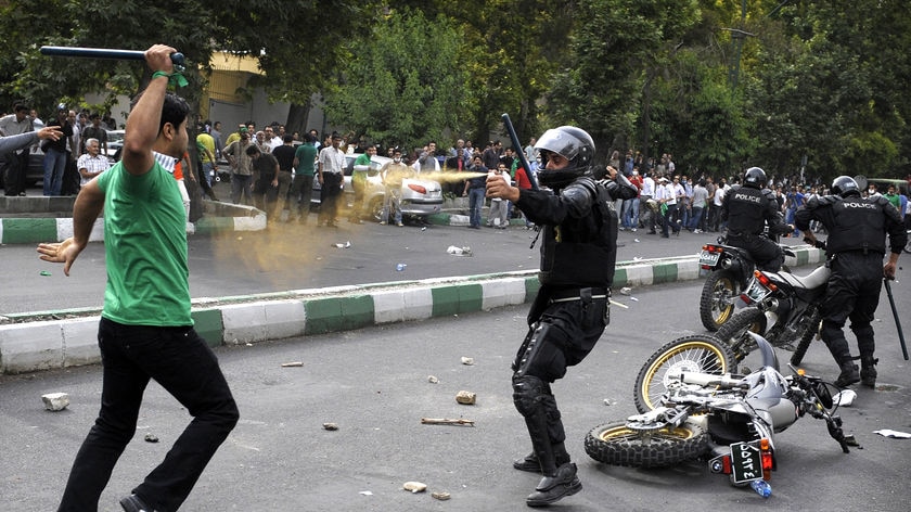 Protester attacks riot police in Tehran after Iran election.