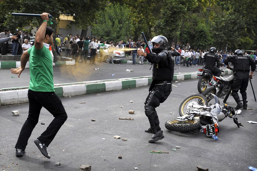 Protester attacks riot police in Tehran after Iran election.