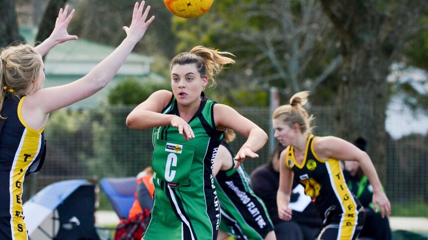 A Kangaroo Flat netballer passes the ball while under pressure from a Kyneton opponent.