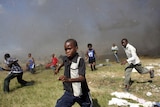 Children run away from an helicopter delivering aid in Haiti after an earthquake