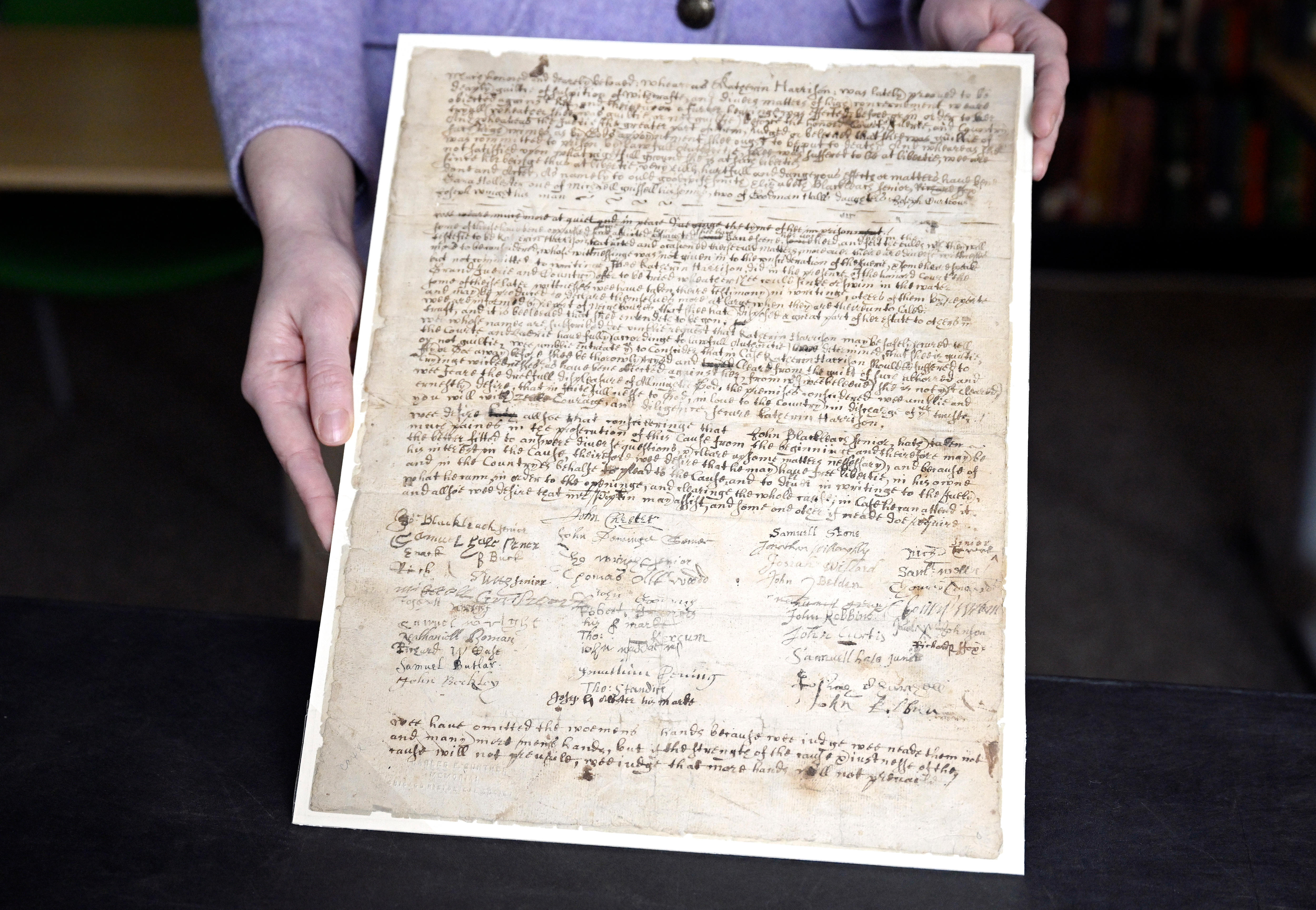 A person shows off a letter that dates back to the 1600s