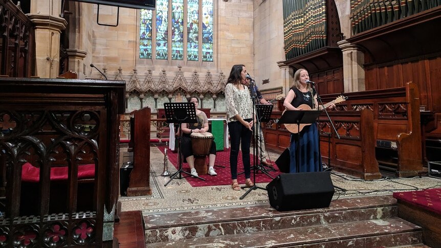 Bianca Manning and pastor Helen Wright singing at a 'change the heart' church service in Sydney before Australia Day.
