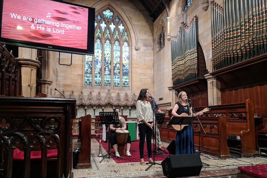 Bianca Manning and pastor Helen Wright singing at a 'change the heart' church service in Sydney before Australia Day.