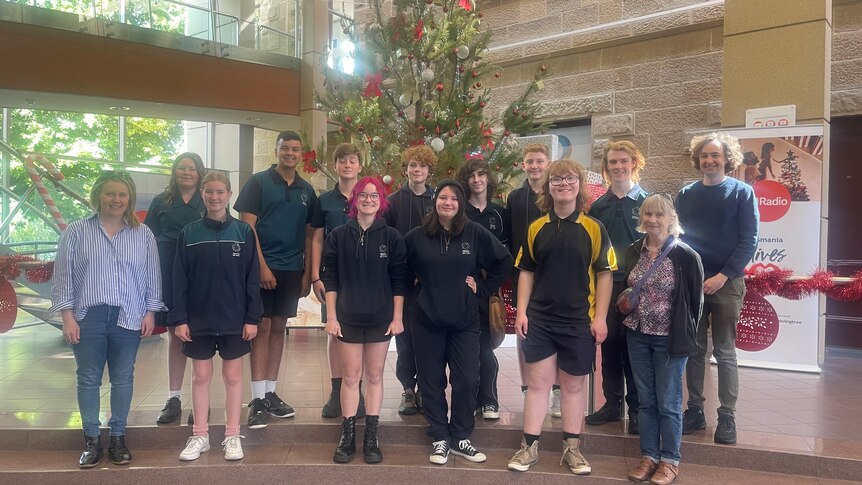 High school students standing in front of the ABC Christmas tree