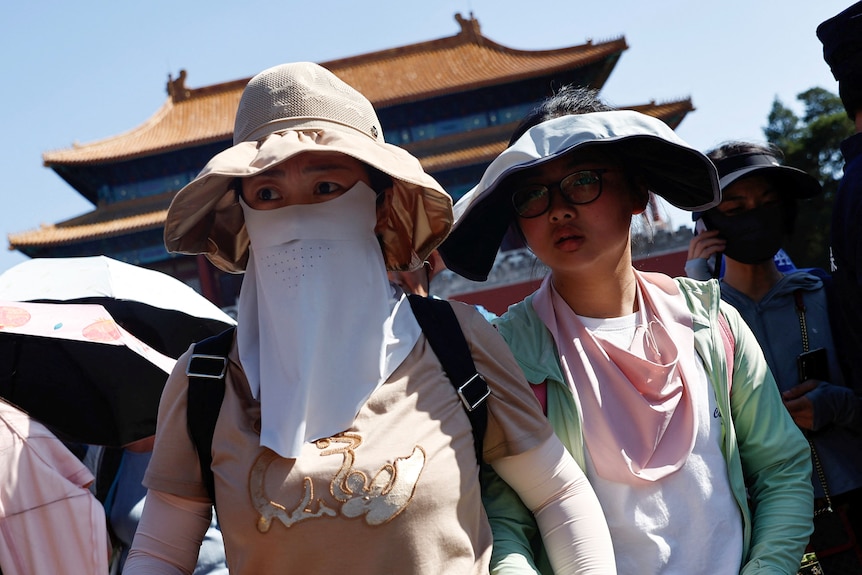 People wearing sun protection gear amid a heatwave in China. 