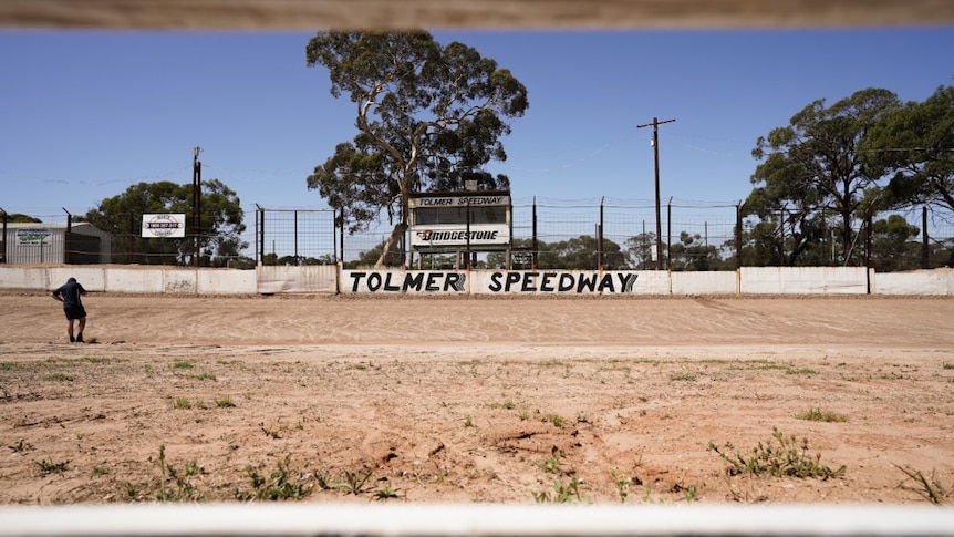 A man on the phone at a speedway track