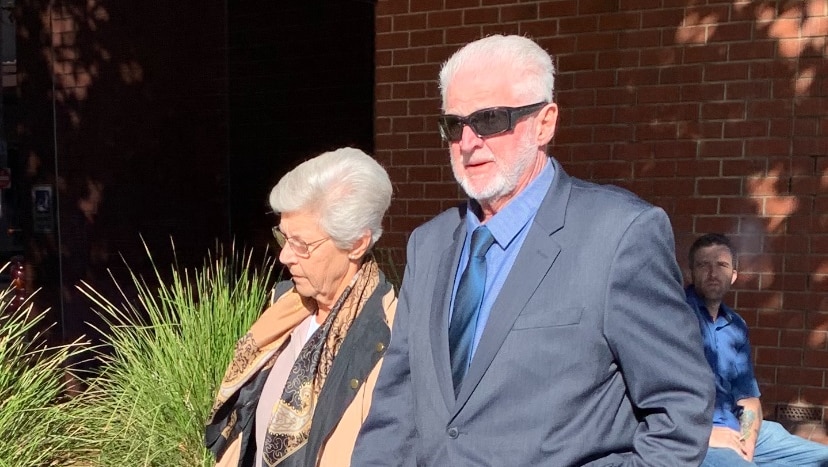 A man in a suit with a woman walking