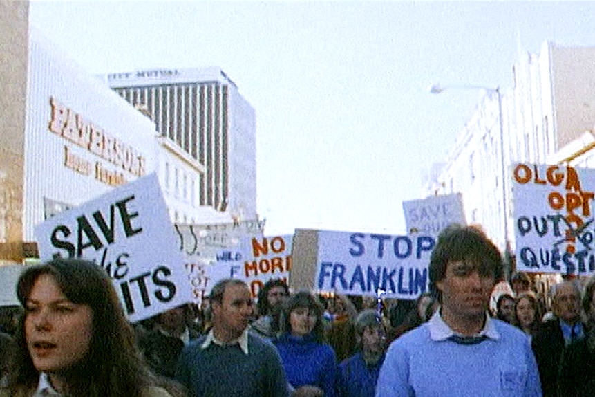 A street photograph of protesters carrying signs demanding an end to the Franklin dam plans.