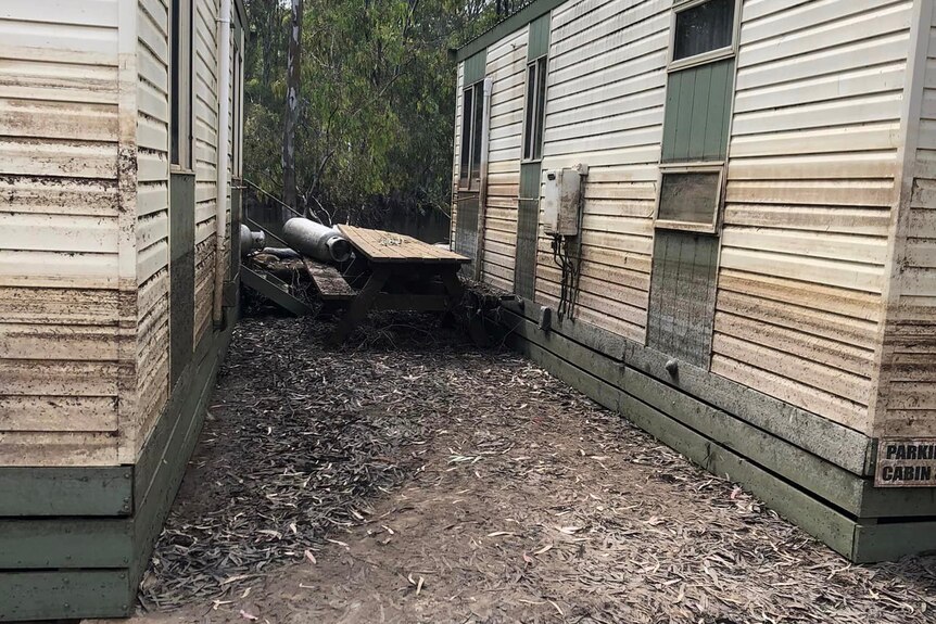 Two cabins in a caravan park and a picnic table damaged by floodwaters