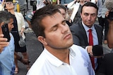 Gable Tostee shuts his eyes as he leaves the Supreme Court and reporters jostle to ask him questions.