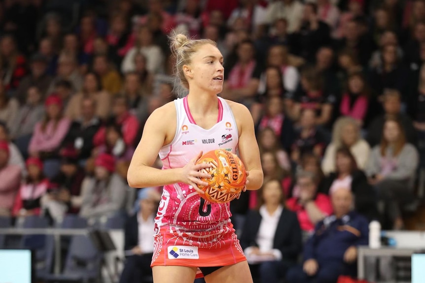 A netballer passes on the ball