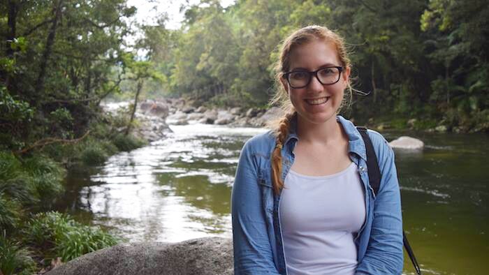 Alexandra Geelan stands in front of a creek in a rainforest while on holiday in Cairns.