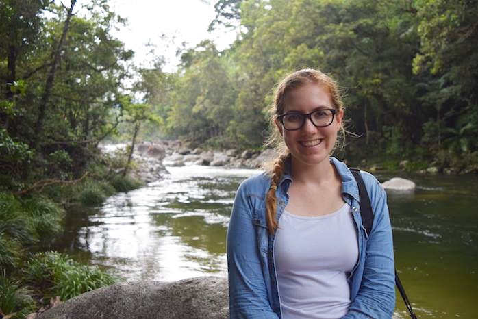 Alexandra Geelan stands in front of a creek in a rainforest while on holiday in Cairns.