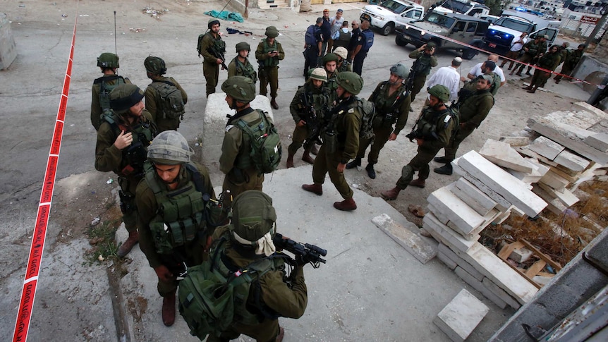 Israeli security forces gather at the scene of a stabbing attack against an Israeli soldier in Hebron, West Bank.