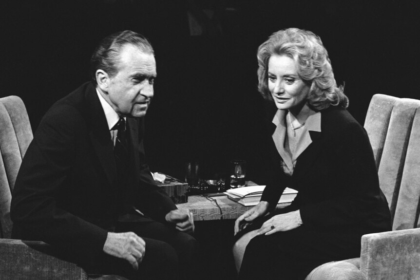 Richard Nixon sitting next to Barbara Walters on a TV set with the image in black and white