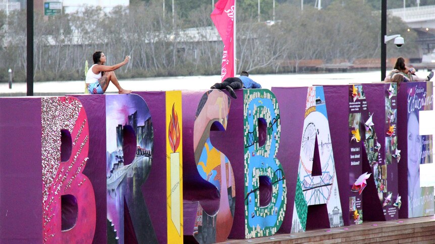 Revellers sit on the Brisbane sign at South Bank, Brisbane, in the early hours of New Year's Day, January 1, 2015.
