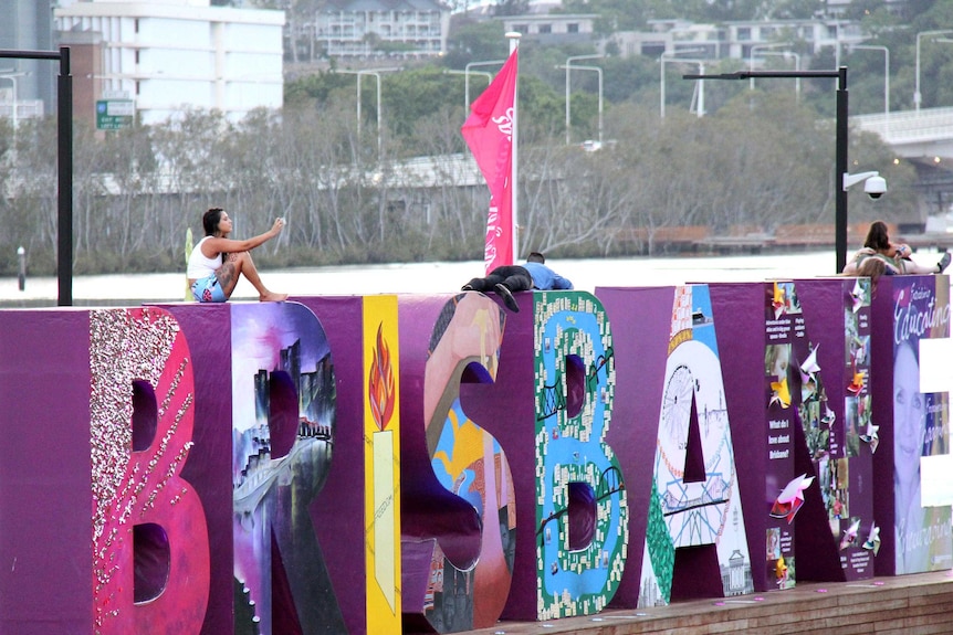 Revellers sit on the Brisbane sign at South Bank, Brisbane, in the early hours of New Year's Day, January 1, 2015.