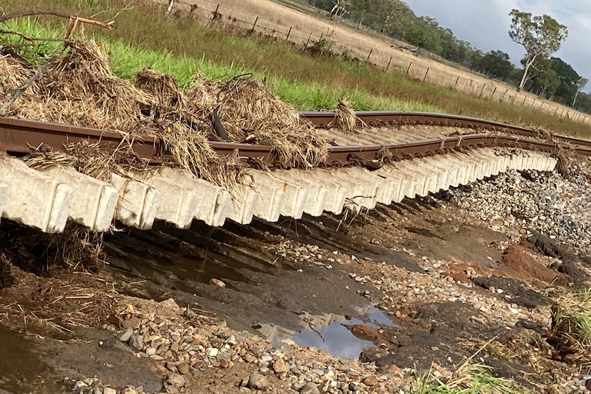 Damaged rail way tracks with mud and water.