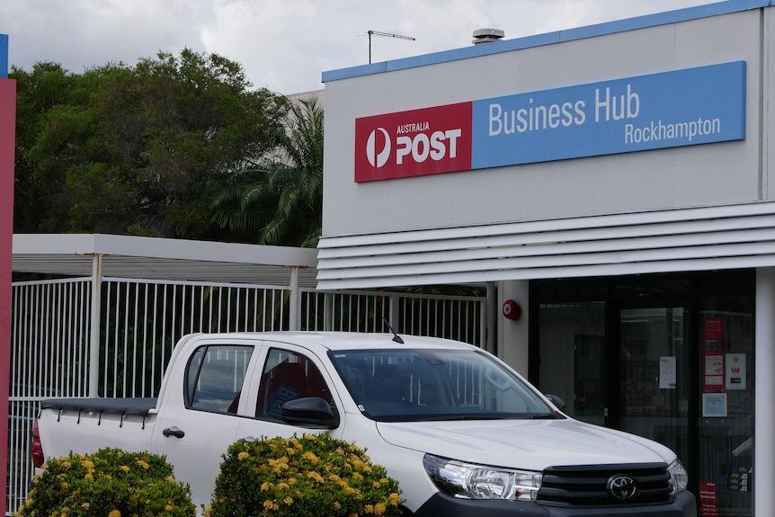 An Australia Post Business Hub building with a car in the driveway,