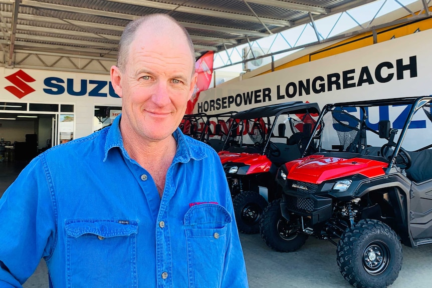 David Mims stands in front of side-by-side ATVs