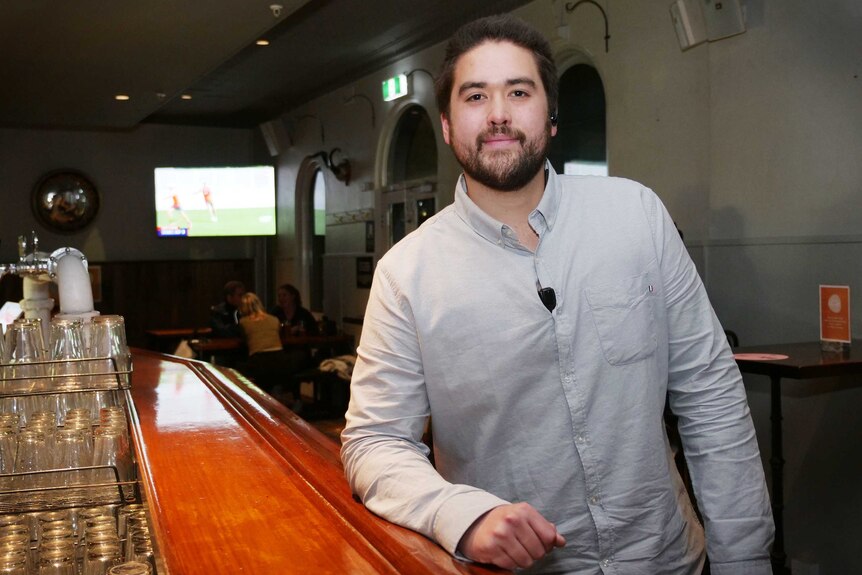 Ben Friend stands at the bar, as customers eat their meals in the background