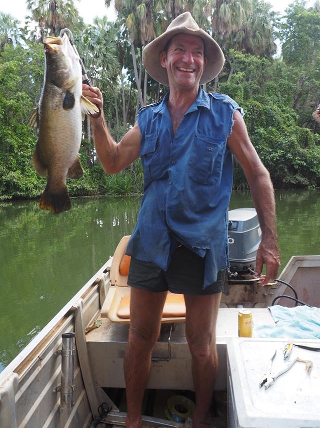 A photo of Mataranka local Des Barritt holding a fish on a boat.
