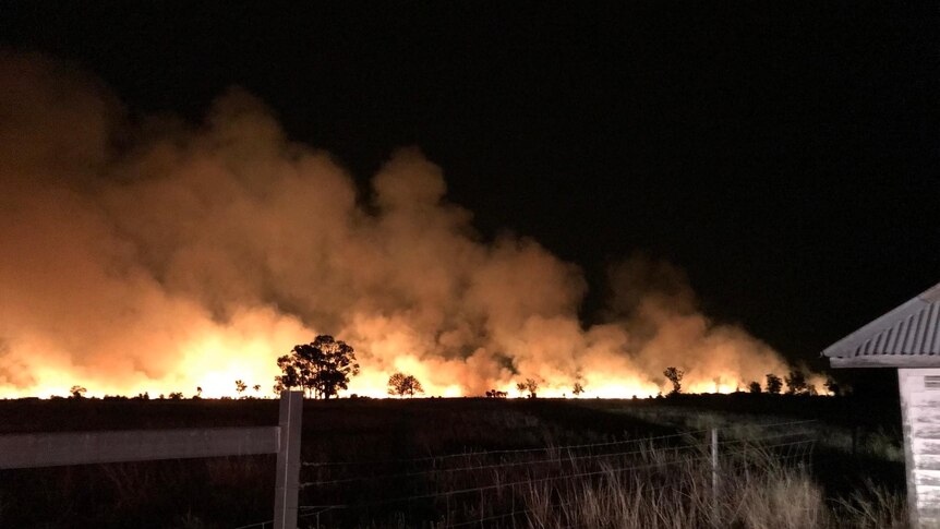 A large bushfire burns at night time.