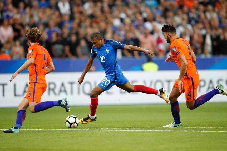 France's Kylian Mbappe (C) runs at the Dutch defence in a World Cup qualifier in Paris.