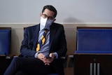 White House deputy press secretary TJ Ducklo sits while wearing a mask
