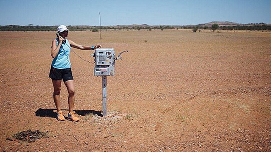 Mina Guli stands at an old telephone, during a stop in the Simpson Desert, South Australia.