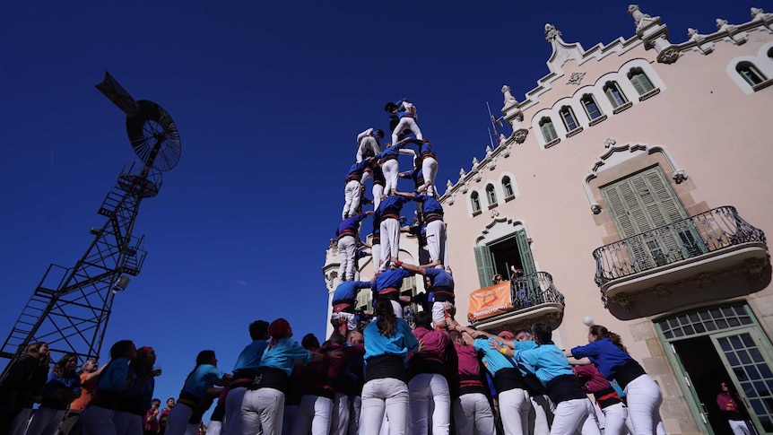 Groups of people form human towers.