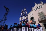 Groups of people form human towers.