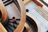 A woman walks on a curved wooden stairwell at the Art Gallery of Ontario, Toronto, Canada.