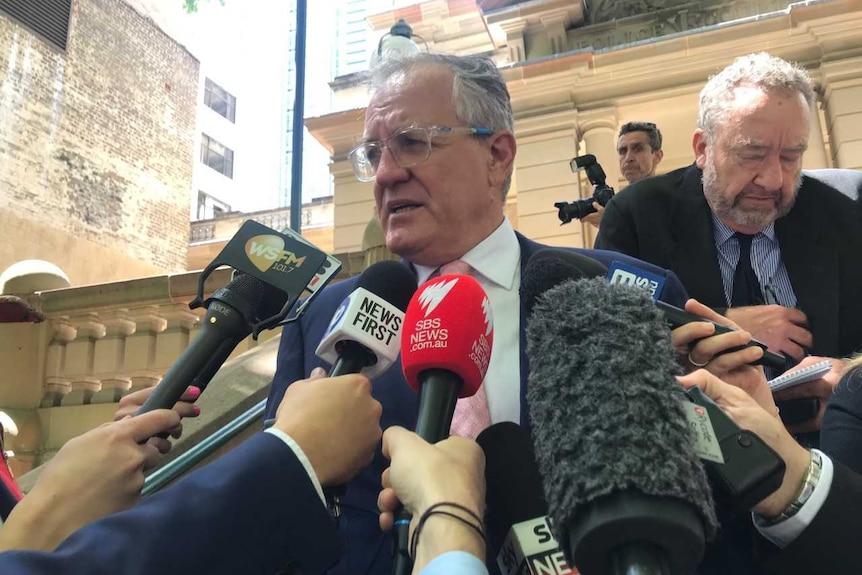 A lawyer speaking to journalists outside court.