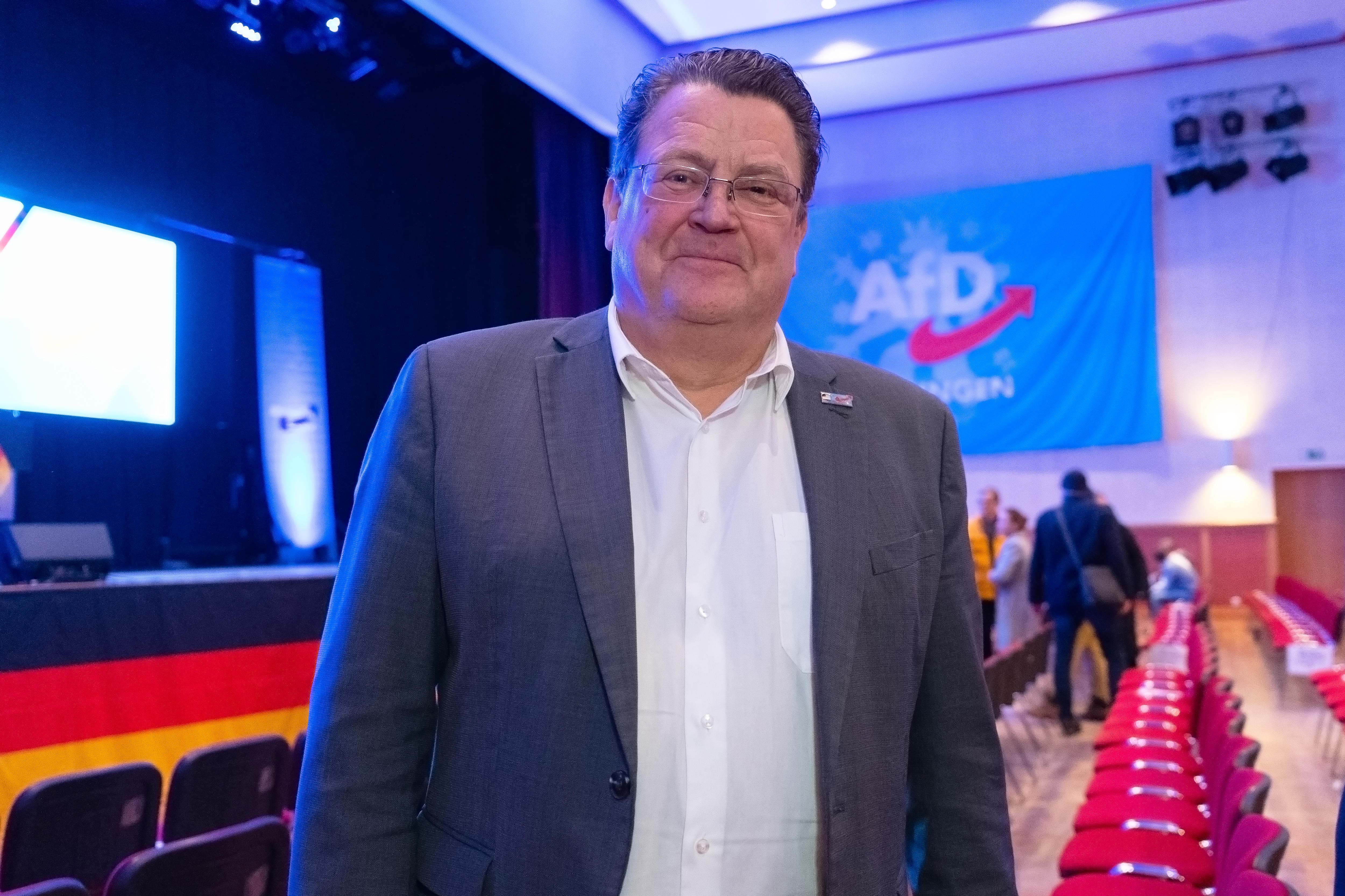 A smiling man wearing a suit jacket.