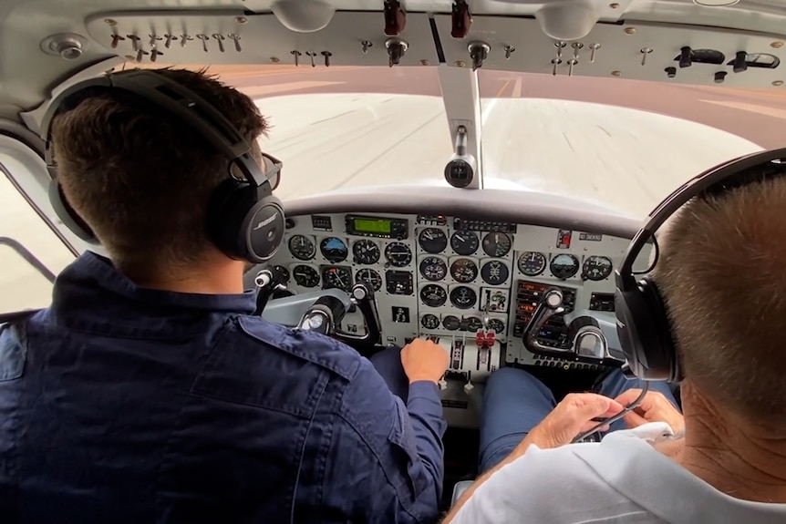 Two men in an aircraft on the left the pilot and on the right is the Incident controller