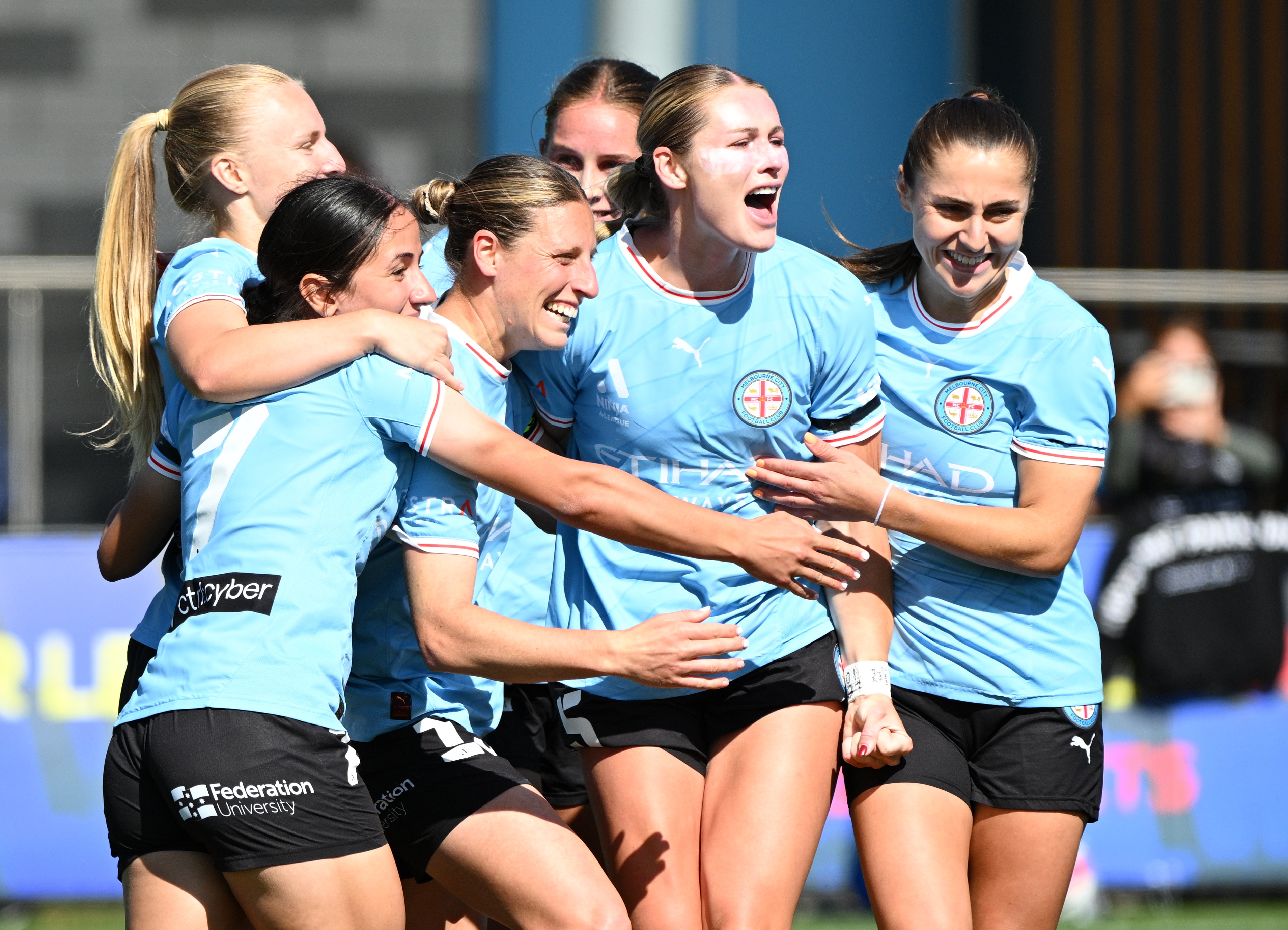 Jogadores de futebol comemoram em campo.