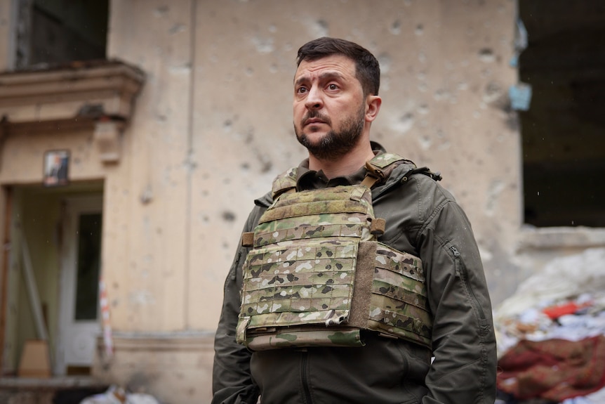  Ukrainian President Volodymyr Zelenskyy looks at a destroyed building as he visits the war-hit Kharkiv region.